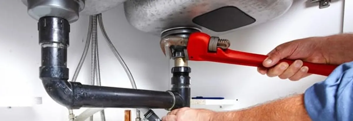 Garbage disposal repair technician tightening the sink drain and disposal connection in Bloomington, IN